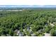 A picturesque aerial view of a residential community surrounded by lush, green forests and trees at 8724 Deerland Grove Dr, Raleigh, NC 27615