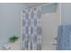 Bright bathroom featuring a tub with shower, patterned shower curtain, and blue accents at 8724 Deerland Grove Dr, Raleigh, NC 27615