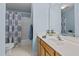 Bright bathroom featuring a tub with shower, patterned shower curtain, and large mirror at 8724 Deerland Grove Dr, Raleigh, NC 27615