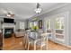 Open dining area with a table and chairs, leading to a living room with a fireplace and a door leading to the outdoors at 8724 Deerland Grove Dr, Raleigh, NC 27615