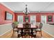 Ornate dining room with a large table, chandelier, and red walls at 8724 Deerland Grove Dr, Raleigh, NC 27615