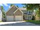 Charming two-story home featuring a two-car garage, manicured lawn, and a welcoming front porch and an American flag at 8724 Deerland Grove Dr, Raleigh, NC 27615