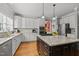 Elegant kitchen featuring granite countertops, stainless steel appliances, an island and white cabinetry at 8724 Deerland Grove Dr, Raleigh, NC 27615