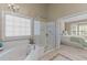 Spacious main bathroom featuring a soaking tub, walk-in shower and a window providing natural light at 8724 Deerland Grove Dr, Raleigh, NC 27615