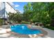 Inviting backyard pool surrounded by lush greenery, a wrought iron fence, and comfortable seating for relaxation at 8724 Deerland Grove Dr, Raleigh, NC 27615