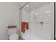 Bathroom features a glass enclosed shower with bench and chrome fixtures next to a toilet with towels at 8724 Deerland Grove Dr, Raleigh, NC 27615