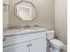 Elegant half-bath features granite countertop, chrome faucet, and octagon mirror at 937 Sedgefield Park Ln, Cary, NC 27519
