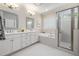 This bathroom features dual vanities, garden tub and tiled shower, creating a spa-like experience at 937 Sedgefield Park Ln, Cary, NC 27519