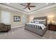 This bedroom has a tufted headboard, ceiling fan, carpet and neutral walls that create a restful retreat at 937 Sedgefield Park Ln, Cary, NC 27519