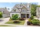 Charming two-story home featuring a stone and siding facade, well-manicured lawn, and inviting front porch at 937 Sedgefield Park Ln, Cary, NC 27519
