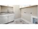 Functional laundry room with granite countertop, undermount sink, tile floor, and washer/dryer hookups at 937 Sedgefield Park Ln, Cary, NC 27519