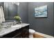 Stylish powder room featuring a modern vanity, granite countertop, and tasteful decor at 937 Sedgefield Park Ln, Cary, NC 27519