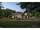 Traditional brick home with dormers, mature trees, manicured lawn, and a well-lit walkway to the front door at 95 Live Oak Dr, Louisburg, NC 27549