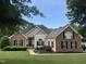 Charming home boasts a manicured lawn, black shutters, and lush landscaping at 95 Live Oak Dr, Louisburg, NC 27549