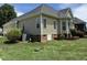 Exterior view of the home and landscaping with brick accents and crawl space entry at 95 Live Oak Dr, Louisburg, NC 27549