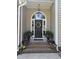 Inviting front entrance with a black door, brick steps, and potted plants at 95 Live Oak Dr, Louisburg, NC 27549