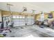 Spacious garage with two overhead doors, fitness equipment, a workbench, and ample storage space at 95 Live Oak Dr, Louisburg, NC 27549