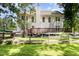 Fenced backyard with mature trees, a spacious deck, and the rear exterior of a two-story home at 101 Rainbow Dr, Carrboro, NC 27510