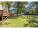 Lush backyard with a wooden fence, mature trees, green grass, and a glimpse of the blue house exterior at 101 Rainbow Dr, Carrboro, NC 27510