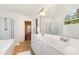 A bright bathroom with double vanity, tile floors, large mirror, and separate tub and glass-enclosed shower at 101 Rainbow Dr, Carrboro, NC 27510