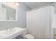 Clean bathroom with a pedestal sink, large mirror, white shower curtain, and neutral color scheme at 101 Rainbow Dr, Carrboro, NC 27510