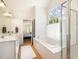 Bright bathroom showcasing a soaking tub beneath an arch window and a glass-enclosed shower at 101 Rainbow Dr, Carrboro, NC 27510