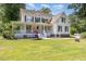 Two-story home with a welcoming front porch and well-manicured lawn, shaded by mature trees at 101 Rainbow Dr, Carrboro, NC 27510