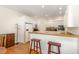 Bright eat-in kitchen boasts white cabinets, wood floors, and breakfast bar seating at 101 Rainbow Dr, Carrboro, NC 27510