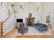 Bright living room with a fireplace, large windows, hardwood floors, and a staircase at 101 Rainbow Dr, Carrboro, NC 27510