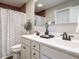 Bathroom featuring double sink vanity, mirror, shower with curtain, and rustic wood accent at 1015 E Maplewood, Benson, NC 27504