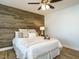 Bedroom with wood-look accent wall, ceiling fan, and natural light at 1015 E Maplewood, Benson, NC 27504