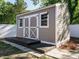 Backyard shed with wooden doors and a small deck, providing extra storage space at 1015 E Maplewood, Benson, NC 27504