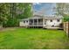 Expansive backyard featuring a well-manicured lawn, mature trees, and a screened-in porch at 102 Lake Dr, Wendell, NC 27591