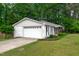 Charming home featuring a white brick facade, a two-car garage, and manicured landscaping at 102 Lake Dr, Wendell, NC 27591