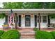 Inviting front porch featuring brick steps and an American flag, with welcoming decor at 102 Lake Dr, Wendell, NC 27591