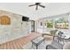 Inviting sunroom with exposed brick, ceiling fan, wood floors, and plentiful natural light at 102 Lake Dr, Wendell, NC 27591