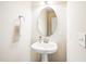 Charming powder room featuring a pedestal sink, oval mirror, and neutral decor for a serene and functional space at 1028 Summerhouse Rd, Cary, NC 27519