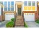 Charming townhome showcasing brick facade, two-car garages, and a welcoming front entrance at 1028 Summerhouse Rd, Cary, NC 27519