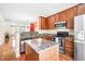 Well-lit kitchen features wood cabinets, stainless steel appliances, granite counters, and an island at 1028 Summerhouse Rd, Cary, NC 27519
