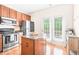 Bright kitchen features wood cabinets, stainless steel appliances, an island, and access to a patio at 1028 Summerhouse Rd, Cary, NC 27519