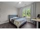 Well-lit bedroom with window views, ceiling fan, and dark wood flooring at 1042 Cardross St, Burlington, NC 27215
