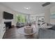 Open-concept living room with a fireplace, large windows, and access to the kitchen at 1042 Cardross St, Burlington, NC 27215