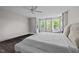 This main bedroom offers a ceiling fan, large windows and dark wood floors at 1042 Cardross St, Burlington, NC 27215