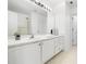 White bathroom with a large mirror, vanity, and a shower behind the door at 10436 Cokesbury Ln, Raleigh, NC 27614