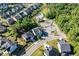 Aerial view of a residential neighborhood featuring homes, green spaces, roads, and a community pool with parking at 105 Blue Prince Trl, Holly Springs, NC 27540