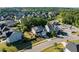 An aerial view of homes in a neighborhood with mature trees, lush lawns, and well-maintained streets on a sunny day at 105 Blue Prince Trl, Holly Springs, NC 27540