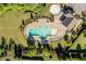 Aerial view of a community pool area with plenty of lounge chairs and beautifully landscaped surroundings at 105 Blue Prince Trl, Holly Springs, NC 27540