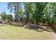 Spacious backyard with lush green grass and tall trees, perfect for outdoor activities and relaxation at 105 Blue Prince Trl, Holly Springs, NC 27540