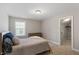 Bright bedroom features neutral walls, plush carpet, and a window providing natural light at 105 Blue Prince Trl, Holly Springs, NC 27540
