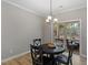 Cozy dining area features a modern chandelier, a dark wood table and chairs, and access to the outdoor patio at 105 Blue Prince Trl, Holly Springs, NC 27540